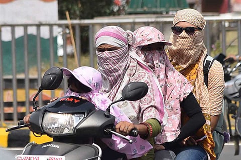 Women on a scooter wearing scarves in summer: Andhra temperatures to soar, IMD predicts 47ºC in some areas