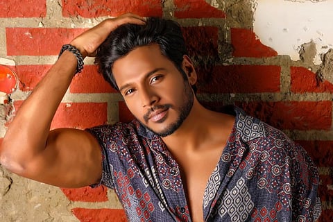 Sundeep is seen striking a pose in the image.