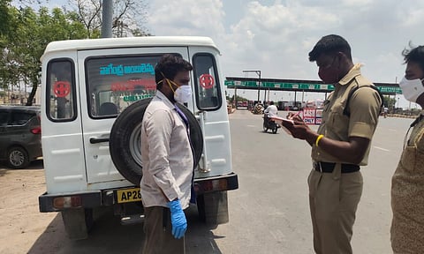 A police officer noting down the details given by the ambulance driver 