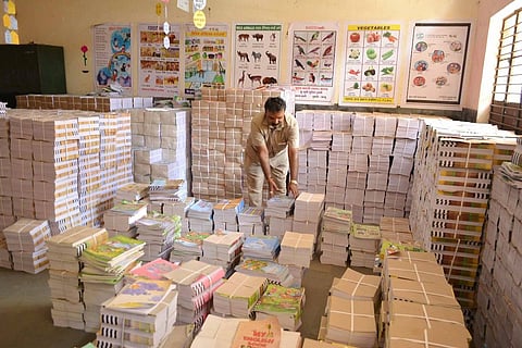 man with textbooks in classroom