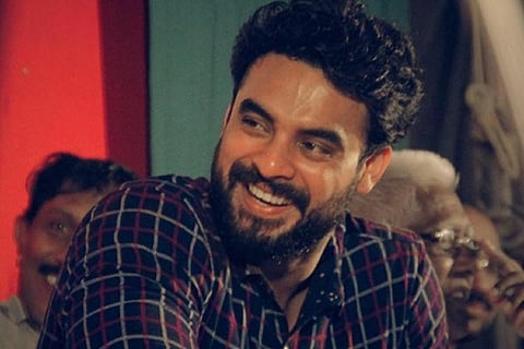 Tovino Thomas is seen in a checked shirt. 
