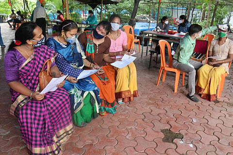A group of transgender persons sitting holding white paper