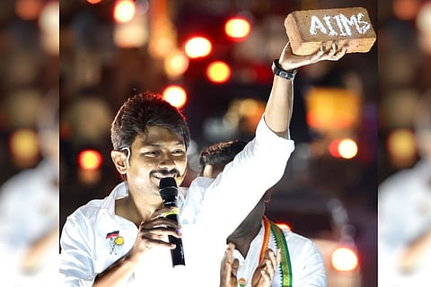 Udhayanidhi stalin holds up a red brick with AIIMS written on it 