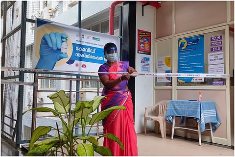 An ASHA worker in Kerala in a pink saree and blue blouse at a COVID-19 Vaccination Centre in Kerala 