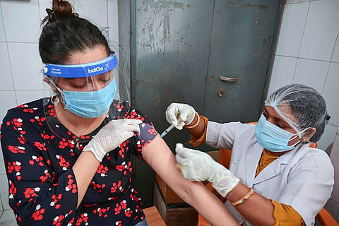 A woman getting vaccinated by a nurse at an Indian hospital