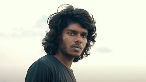 Vedan wearing a black T-shirt looking into the camera