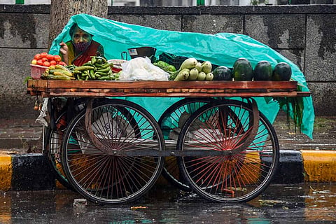 A pushcart vegetable seller in the rain