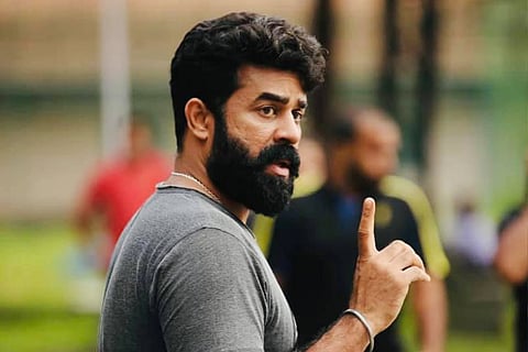 Actor Vijay Babu in a grey shirt pointing his index finger