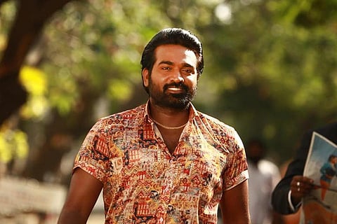 Vijay Sethupathi with beard and in a colourful shirt walking on the road