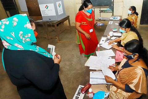 A polling booth with voters and polling officials