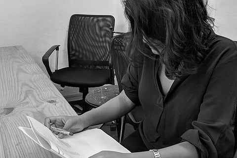 An image of a woman working, sitting in a chair 