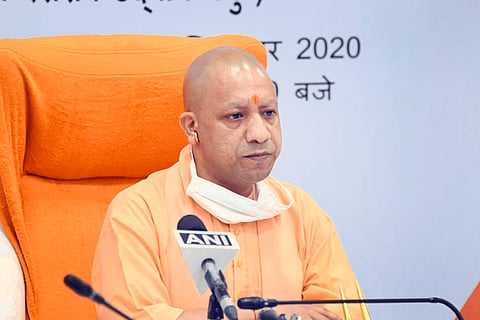 Uttar Pradesh Chief Minister Yogi Adityanath sitting on a saffron coloured chair
