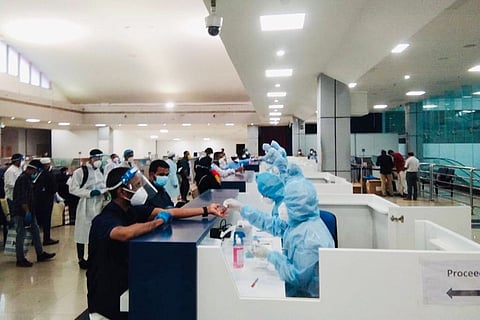 People at the airport with masks and hazmat suits