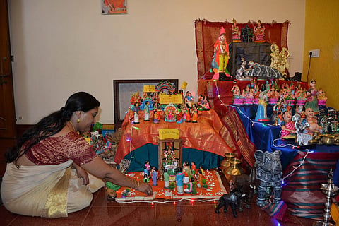 A woman arranges dolls for Golu at her house