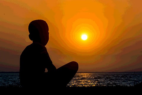 An image of a boy staring at the sun 