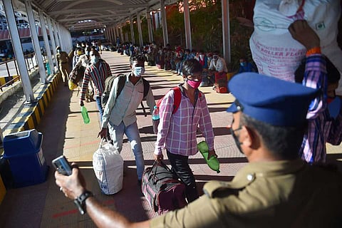 Chennai police assisting migrant workers to board a train