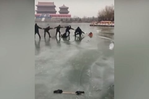 Watch: Locals in China form human chain to help pull out family from frozen lake