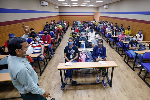 A professor and students in a college classroom
