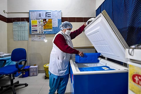 Health worker looking at COVID-19 vaccine cold storage 