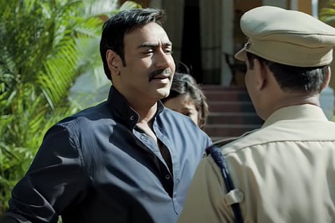 Ajay Devgn standing in front of policeman in Drishyam