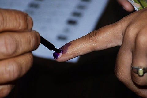 Voter's index finger getting inked 