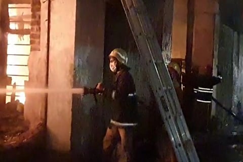 A fire officer dousing the fire using water 