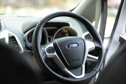 The steering wheel of a car with Ford logo on it