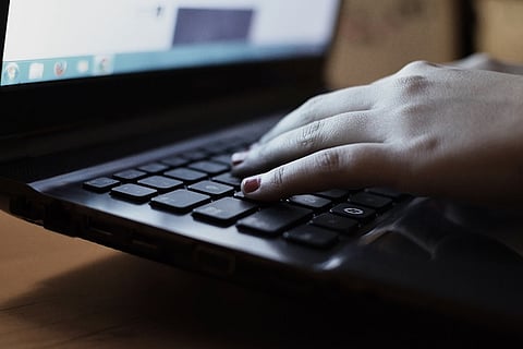 A file image on a person on a laptop