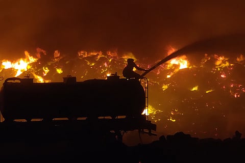 A firefighter attempts to douse the flames at Perungudi landfill on the first day of the blaze