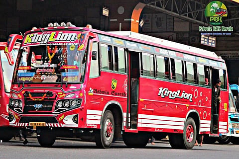 A pink painted private bus in Kerala halted at a bus station 
