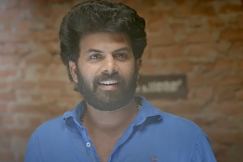 Sunny Wayne in a blue shirt 