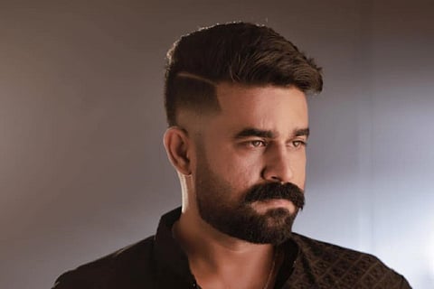 Vijay Babu in a black shirt against a gray-tone backdrop