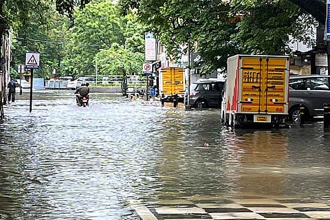 An inundated street with a few vehicles plying in Chennai 