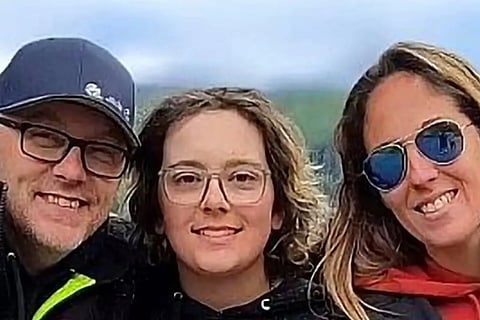 Carson Cleland, middle, with his parents