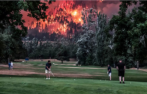 Golfers in Oregon finish a round ahead of a looming forest fire.