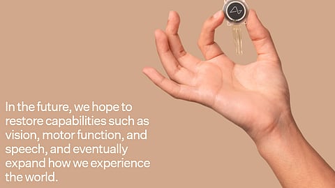 Neuralink chip held in human hand