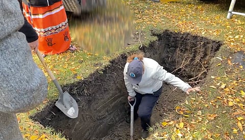Workers exhume one of the unidentified bodies in Edmonton