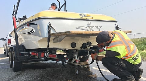 Inspectors decontaminate a boat for invasive species at an inspection station in Alberta.
