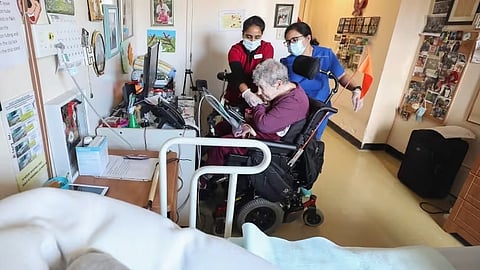 St. Vincent's Nursing Home continuing care assistants Kamal Kaur, left, and Sherlyn Monteroso, right, help a resident at its location in Halifax in this 2021 file photo.