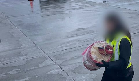 An airport employee carries the empty case for National Chief Cindy Woodhouse Nepinak's headdress, after it was taken from her on Wednesday. Air Canada appears to have followed normal procedures for odd-sized baggage. The chief carried her headdress on her lap for the flight