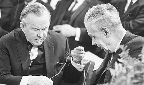 John Diefenbaker (right) looks on as Lester Pearson (left), his great political rival in the late 1950s and 1960s, attempts to uncoil the cord of a translation earpiece. Neither leader spoke fluent French. John Robson assesses the assessment of both men in a new book from columnist and author John Ibbotson