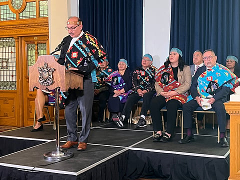 Speaker of the Legislative Assembly of British Columbia Raj Chouhan stands behind a podium on stage with First Nations partners. 