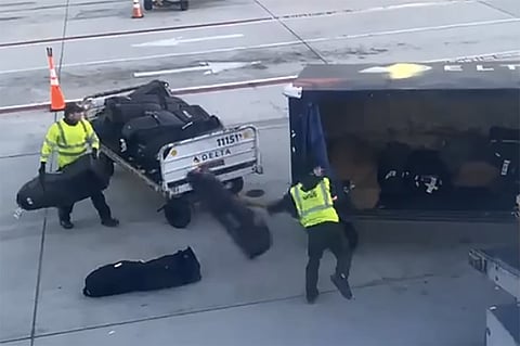 Delta ground crew throws golf bags on the tarmac