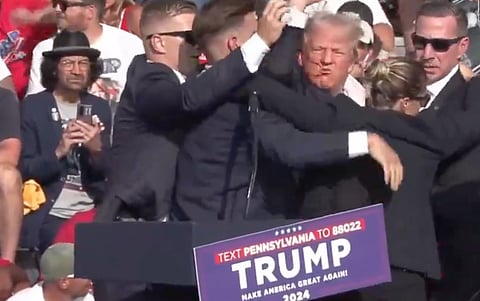Bloodied Trump bundled off stage