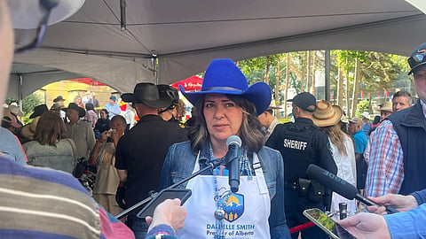 There's always politics done at the Calgary Stampede, says writer Josh Andrus. Here Premier Danielle Smith gives comments while flipping pancakes.