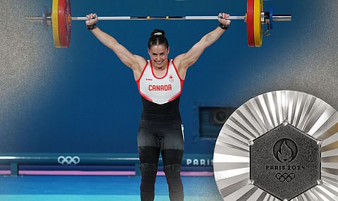 Olympian Maude Charron hoists the silver medal for Canada in weightlifting 