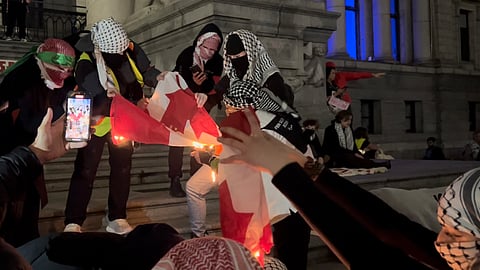 Demonstrators burning Canadian flags
