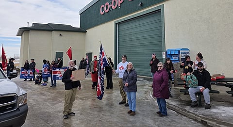 Individuals in Wetaskiwin standing outside of a Stay Free Alberta event, looking to "remind" people about First Nations Treaties. 
