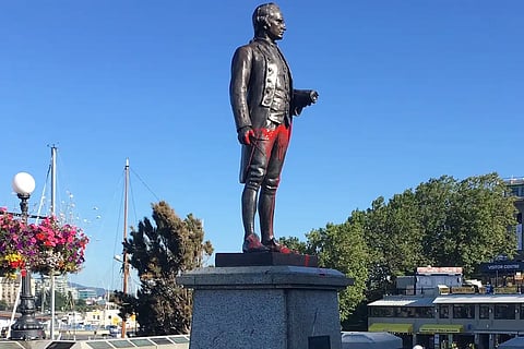 Statue of English explorer James Cook at Victoria Harbour is splattered with paint, August 2020. On Canada Day the following year, after annual celebrations were cancelled in the wake of secret grave claims at Kamloops, the statue was torn down by a mob and thrown into the harbour.