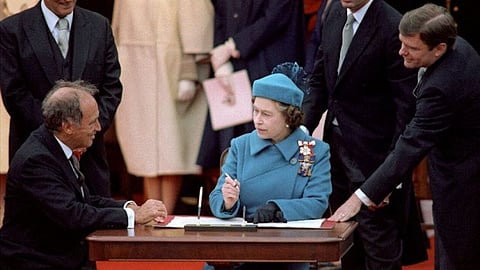 As Prime Minister Pierre Trudeau watches, HM Queen Elizabeth II signs an agreement passing control of the British North America Act to Canada. It has since been known as the Constitution Act. 